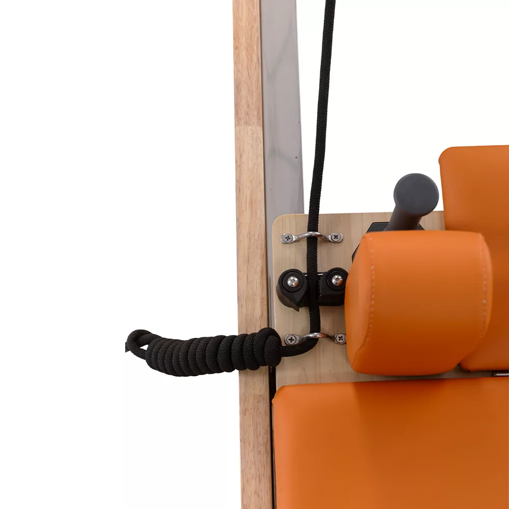 Children Pilates reformer pulley system with orange headrest detail Children Pilates reformer pulley system with orange headrest detail